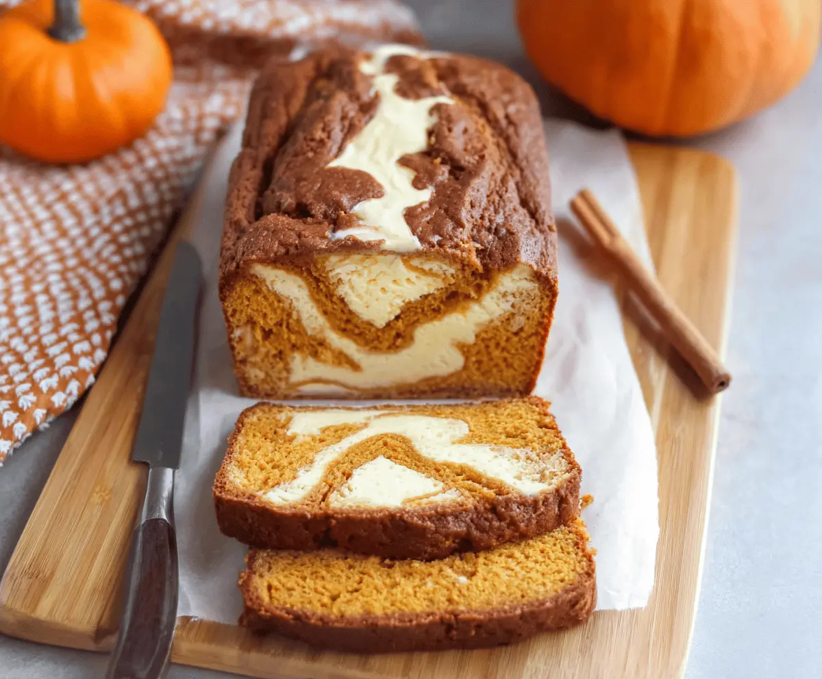 Delicious homemade Pumpkin Cream Cheese Bread sliced and served on a plate, showcasing moist pumpkin loaf with cream cheese swirl and warm autumn spices