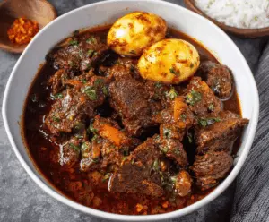 Savory Ethiopian Beef Stew served with traditional injera bread, showcasing tender beef chunks, aromatic spices, and rich tomato-based sauce.
