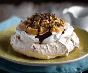 Delicious pumpkin pavlova topped with whipped cream and seasonal pumpkin decorations, perfect for fall dessert