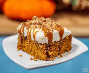 Delicious Pumpkin Poke Cake with creamy frosting and fall-inspired decoration, perfect for autumn desserts.