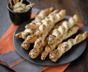 Spooky Witch Finger Breadsticks with almond fingernails on a platter, perfect for Halloween parties