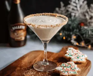 A close-up of a Baileys Sugar Cookie Martini in a elegant glass garnished with a cookie and whipped cream.