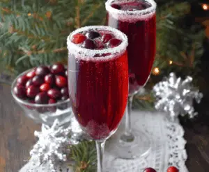 Festive Cranberry Christmas Mimosa with fresh cranberries and orange slices in a sparkling flute.
