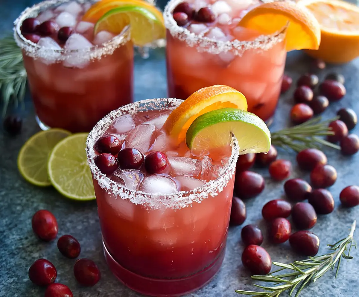 Fresh Cranberry Orange Margarita in a glass with cranberries and orange garnish, perfect for holiday celebrations.