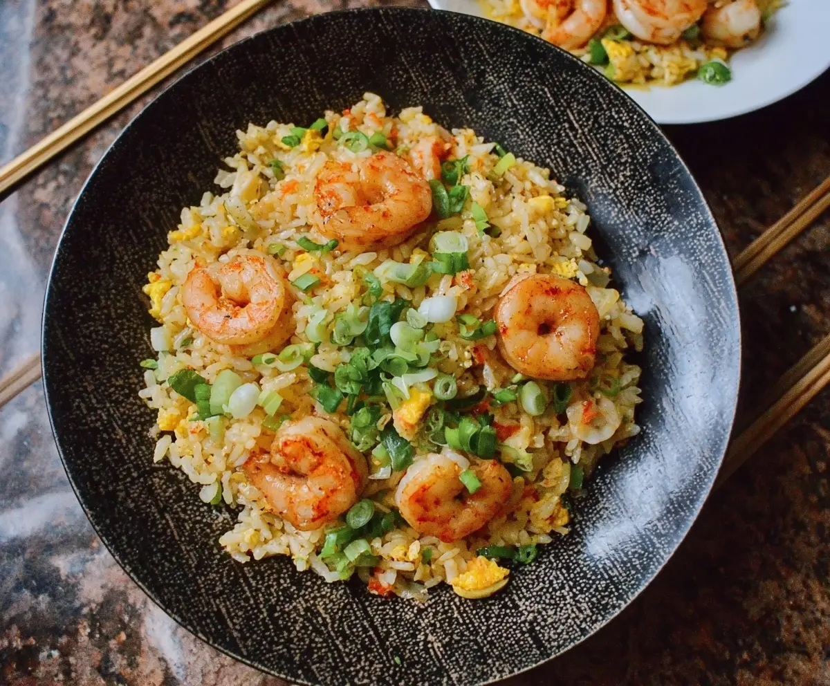 Delicious shrimp garlic fried rice served on a plate with fresh herbs