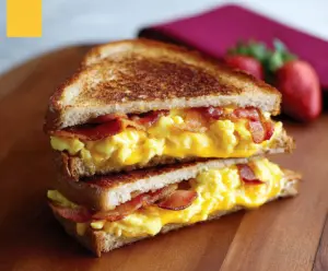 Delicious breakfast grilled cheese sandwich filled with scrambled eggs and crispy bacon, perfect for morning cravings.