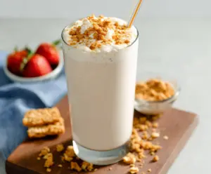 Creamy cottage cheese shake in a glass with a straw, garnished with fresh fruit.