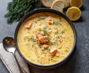 Creamy dill salmon soup served in a bowl garnished with fresh dill and lemon slices