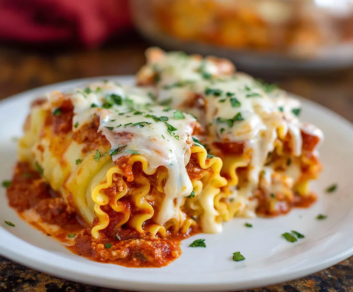 Delicious homemade lasagna roll ups with melted cheese and savory sauce on a plate.