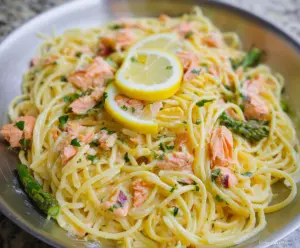 Delicious lemon butter salmon pasta served on a plate with fresh lemon slices and herbs
