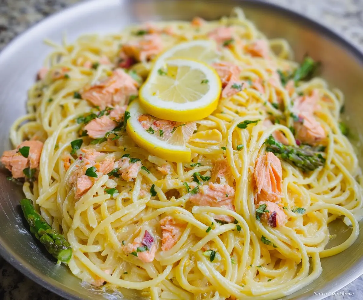Delicious lemon butter salmon pasta served on a plate with fresh lemon slices and herbs