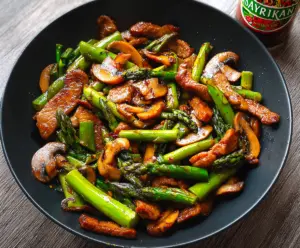 Delicious pork and asparagus stir fry served in a bowl, highlighting fresh ingredients and vibrant colors.