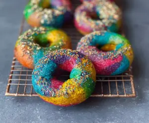 Colorful rainbow bagels with vibrant swirls and a glossy finish for a fun breakfast treat.