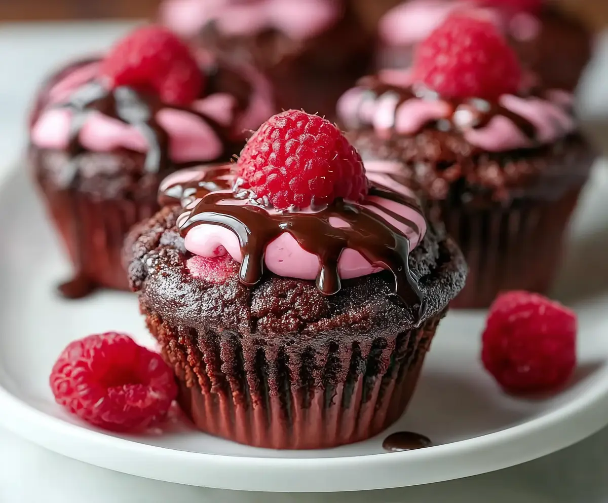Delicious raspberry chocolate lava cupcakes with gooey center and fresh raspberries on top.