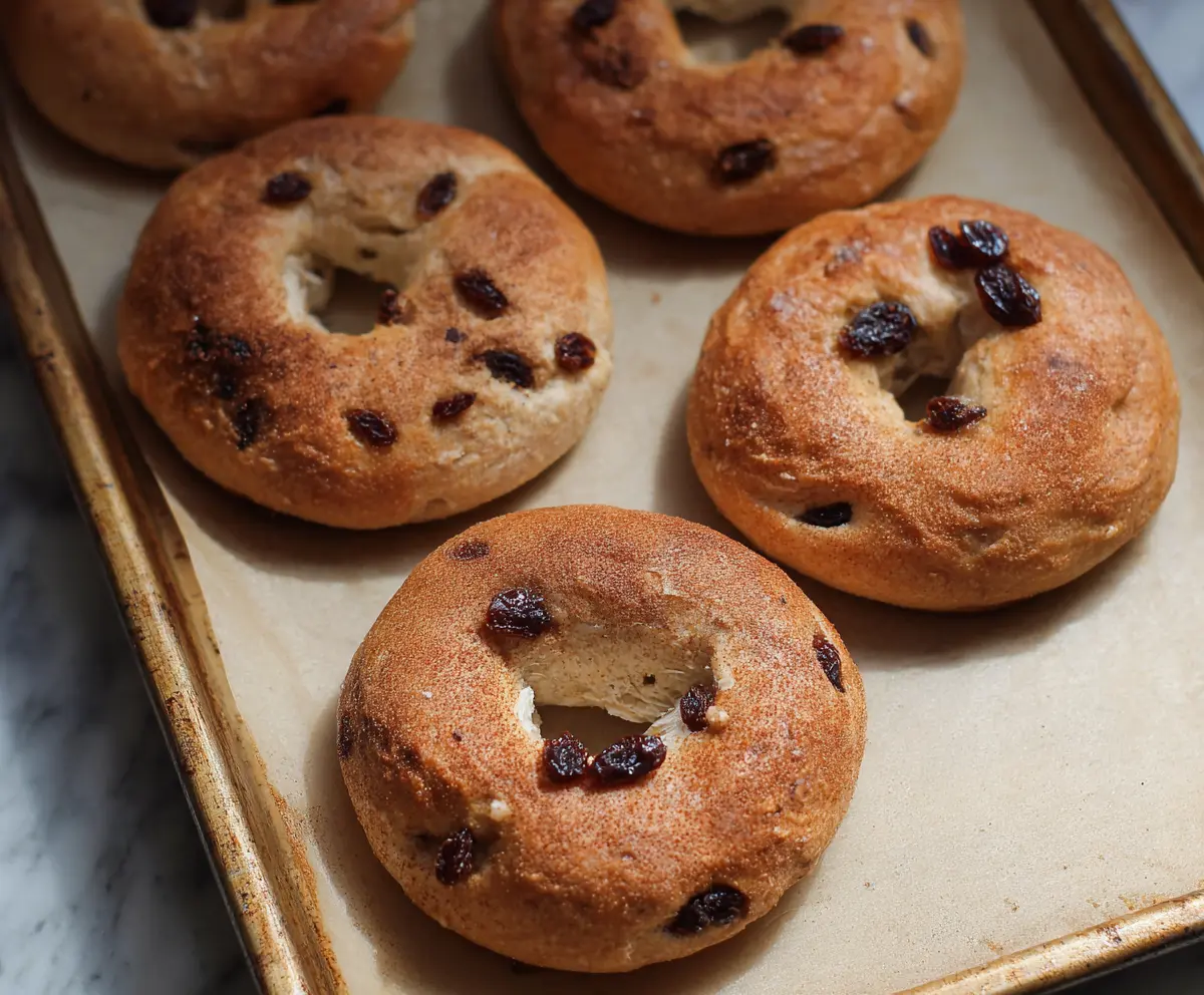 Freshly baked cinnamon raisin yogurt bagels sliced and ready to enjoy, featuring a golden crust and sweet raisin filling.