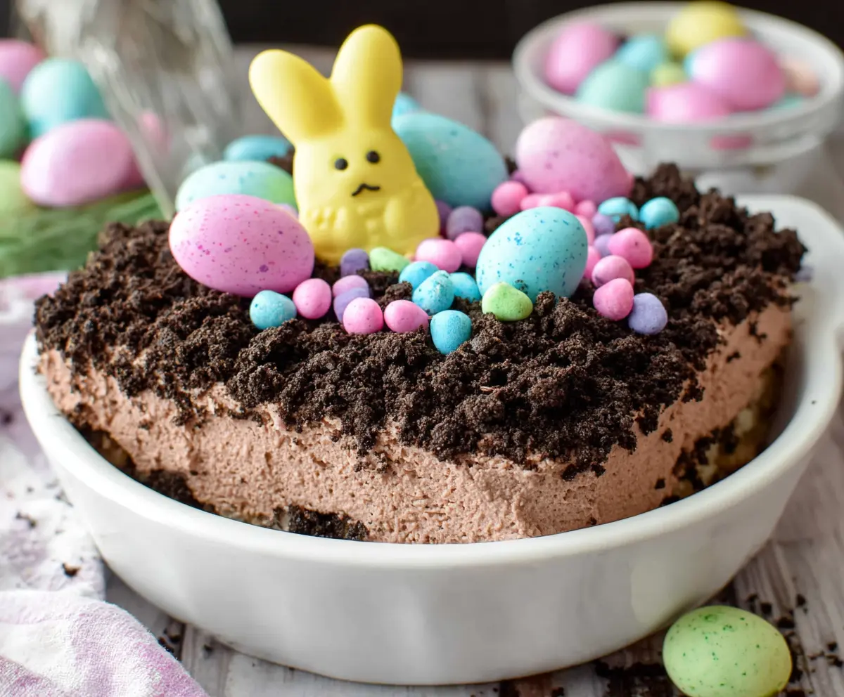Delicious Easter Dirt Cake with chocolate pudding, crushed cookies, and colorful sprinkles served in a festive dish