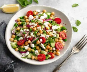 Fresh Mediterranean Pea Salad with feta cheese, tomatoes, and olives in a bowl