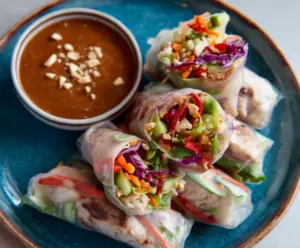 Delicious pork spring rolls with fresh vegetables served with a creamy peanut lime sauce.
