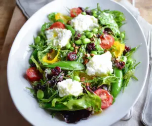 Fresh spring salad with goat cheese, colorful mixed greens, cherry tomatoes, and a light vinaigrette.