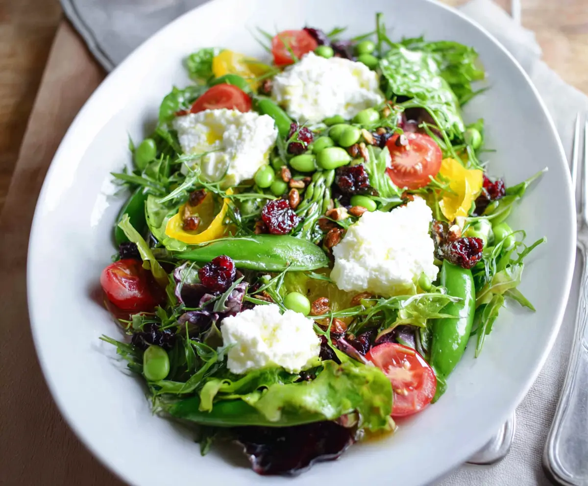 Fresh spring salad with goat cheese, colorful mixed greens, cherry tomatoes, and a light vinaigrette.